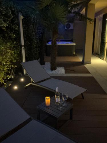 a patio at night with a table and wine glasses at Colonno Panoramica Lago Di Como in Colonno
