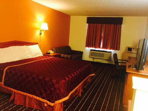 a hotel room with a bed and a couch at Texas Inn and Suites Lufkin in Lufkin
