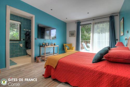 a bedroom with a red bed and a bathroom at La lunera in Porticcio