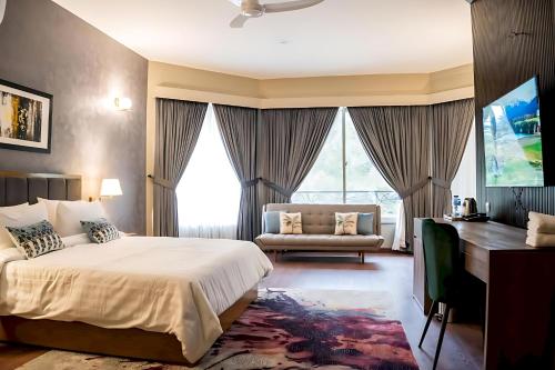 a bedroom with a bed and a desk and a couch at Hillside Residence E-7 by Paramount Hospitality in Islamabad