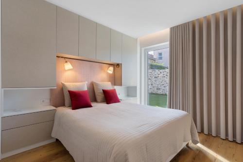 a bedroom with a large white bed with red pillows at Vila Santa Luzia 4 in Fátima