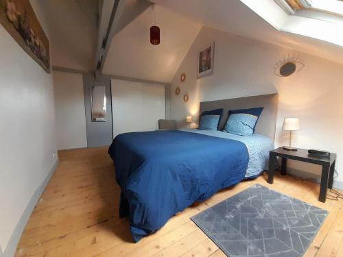 a bedroom with a blue bed and a table at lgbt friendly in Dinan