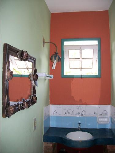 a bathroom with a mirror and a sink at Pousada Beija-Flor in Lavras Novas