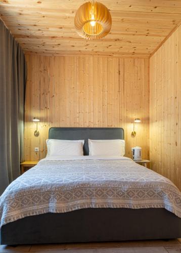 a bedroom with a bed with a wooden wall at Southlux in Tossor