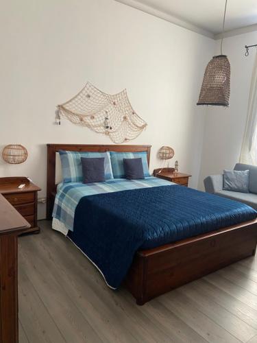 a bedroom with a blue bed and a couch at Casa Marietta in San Vito lo Capo
