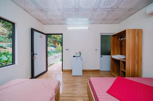 a room with two beds and a room with a chalkboard at Windy Homestay in Cat Ba