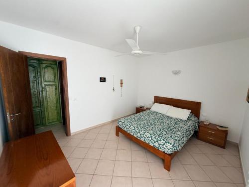 a bedroom with a bed and a green door at Top Leme Bedje in Santa Maria