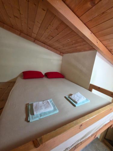 a bed in a room with two red pillows on it at Apartmani Dado in Sutomore