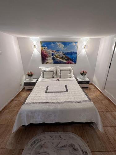 a bedroom with a large bed with a painting on the wall at Résidence Les Camélias in Tabarka