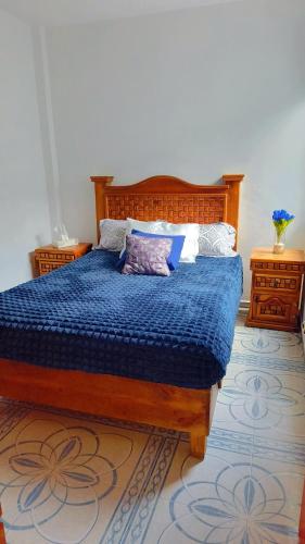 a bedroom with a bed with a blue comforter at Estadio GNP and Airport AICM in Mexico City