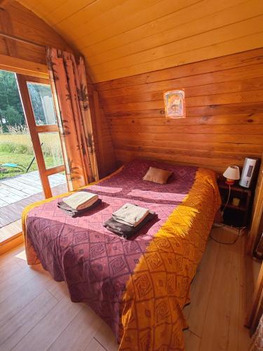 a bedroom with a bed in a wooden room at Les Gîtes de Botte in Duras