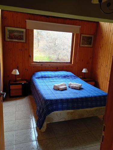 a bedroom with a bed with two towels on it at Casas Nahuilen in San Martín de los Andes