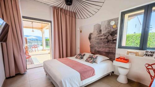 a bedroom with a bed and a large window at Casa nova in Sagone