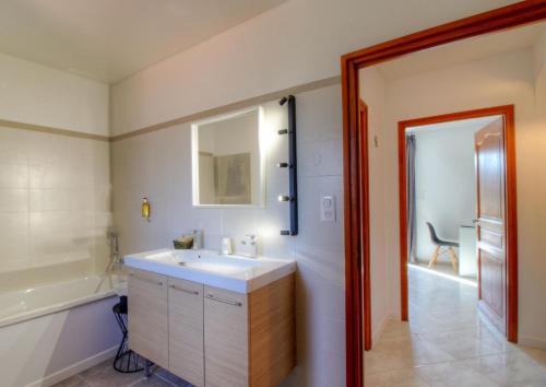 a bathroom with a white sink and a tub and a sink at Casa nova in Sagone