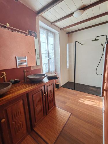 a bathroom with two sinks and a large mirror at Les Gîtes de Botte in Duras
