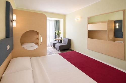 a hotel room with a bed and a chair at Zenith Hotel in Mamaia