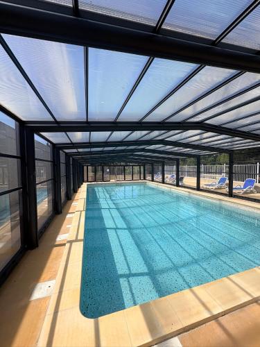 an indoor swimming pool with a glass ceiling at Maison avec jardin in Calvisson