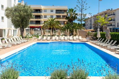 a swimming pool with chairs and umbrellas at a hotel at THB Dos Playas - Adults Only in Cala Ratjada