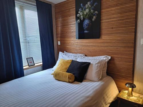 a bedroom with a bed with two pillows on it at B&B The White House in Westzaan