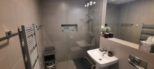 a white bathroom with a sink and a shower at Apartament Lazurowy 53 z tarasem i SPA in Gródek Nad Dunajcem
