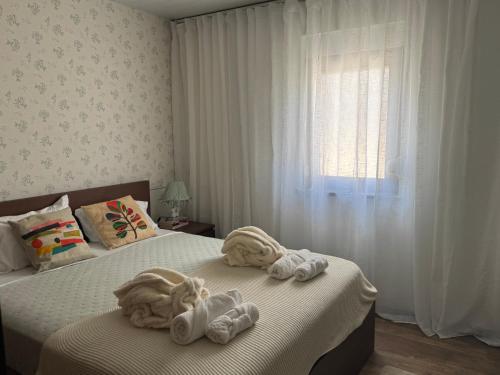 a bedroom with two beds with towels and a window at The Green Retreat in Torres Vedras