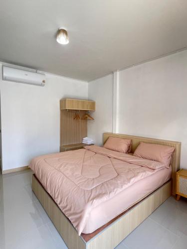 a bedroom with a large bed with pink sheets at แอดโฟร์รีสอร์ท in Ban Phrao