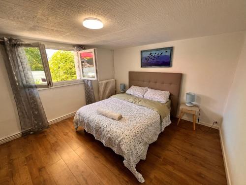 a small bedroom with a bed and two windows at Appartement causy in Gonfreville-lʼOrcher