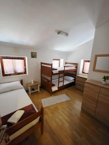 a small room with two beds and a table at Hostel Obrovac in Obrovac