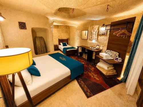 a bedroom with a bed and a desk in a room at Aden Hotel Cappadocia in Uçhisar
