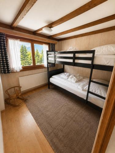 two bunk beds in a room with a rug at Chalet Montana mit Bergblick in Brunig