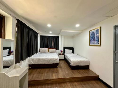 a hotel room with two beds and a window at Hotel Arba in Kuala Lumpur