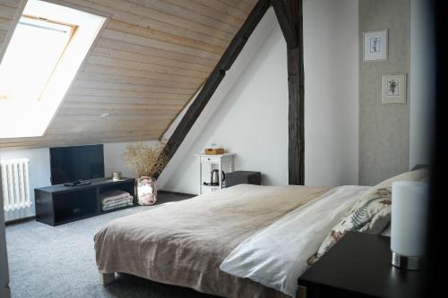 a bedroom with a large bed and a skylight at Statek Český Dvůr in Postupice