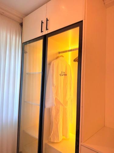 a wardrobe with a white robe in it at J-Ver Haven in Kasoa