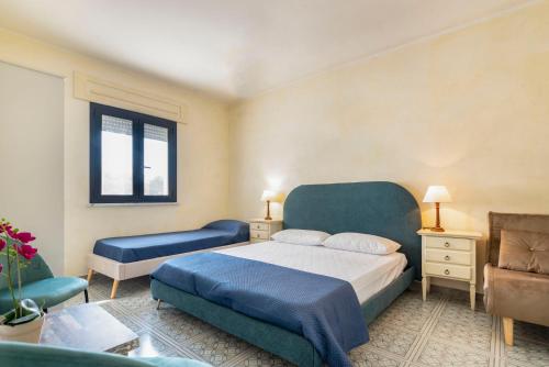 a bedroom with a blue bed and a chair at Casa Baia smeraldo in Leuca