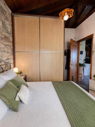 a bedroom with a large white bed with a green blanket at Mountain Escape Villa in Gamvriá