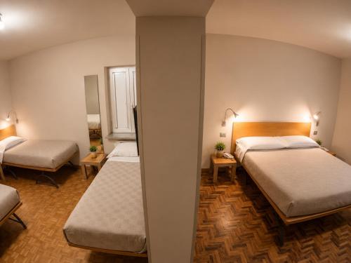 a hotel room with two beds and a mirror at San Lorenzo Si Alberga in Camigliatello Silano