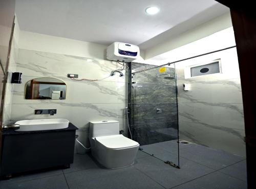 a bathroom with a toilet and a sink and a shower at Hotel Deep Khirsu in Malaī