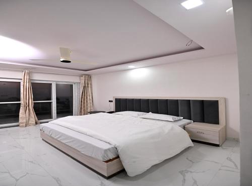 a large white bedroom with a large white bed at Hotel Deep Khirsu in Malaī