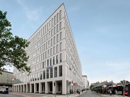 a large white building on a city street at Aparthotel Adagio Bremen City in Bremen