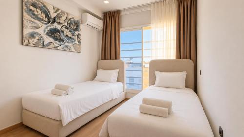 two beds in a room with a window at Spacious Triplex in Harhoura in El Harhoura