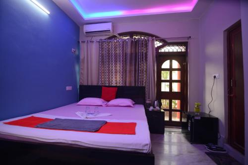 a bedroom with a bed with pink and red pillows at Harshita's Guest House in kolkata