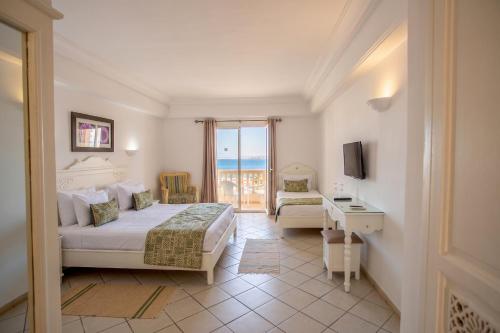 a hotel room with two beds and a balcony at Zodiac Hôtel & Aqua Park in Hammamet