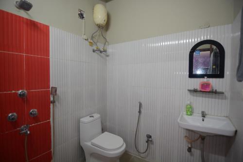 a bathroom with a toilet and a sink at Harshita's Guest House in kolkata