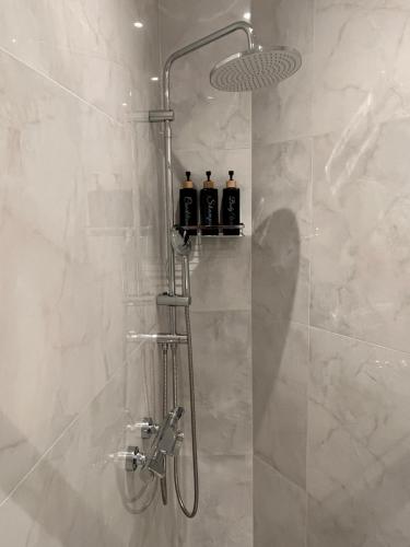 a shower with three bottles on a shelf in a bathroom at Skyway Comfort Residences in Spata