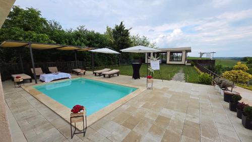 a swimming pool with umbrellas and a house at Vino & Vista in Ripanj
