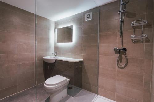 a bathroom with a toilet and a glass shower at Home Farm & Lodge in Bawtry