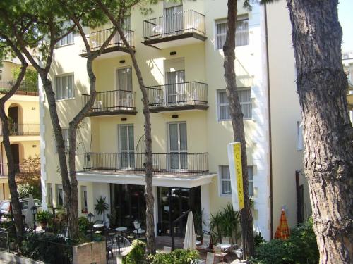hotel z drzewami przed nim w obiekcie Hotel Cortina w Rimini
