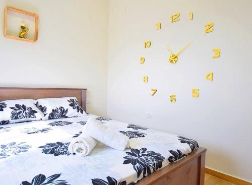 a bedroom with a bed with a clock on the wall at חלום בהר- 2 סוויטות מפנקות עם בריכה ואמבט ספא במתחם in ‘Ein el Asad