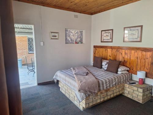 a bedroom with a bed with a wooden headboard at Schweizer Lodge in Schweizer-Reineke