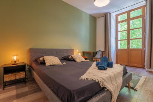 a bedroom with a large bed and a window at T4 Cosy - Château - Wifi in Aubenas